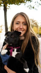 Portrait picture of a woman with a black-and-white dog